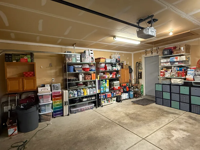 Same actual Indianapolis garage after, showing regrouped shelving, cabinets and added cube storage